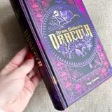 Dłoń trzyma ozdobną książkę z wampirem i czaszkami. To "Dracula" Brama Stokera, autora tej mrocznej opowieści.