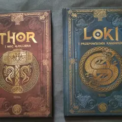 Dwie książki z motywami nordyckimi: "Thor i moc Mjolnira" z młotem, oraz "Loki i przepowiednia Ragnarök" z wężem. Poznaj symbole nordyckie i ich znaczenie.