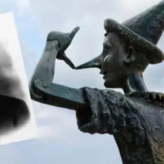Carlo Collodi, autor książki Pinokio, na tle rzeźby drewnianego chłopca z długim nosem.