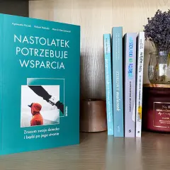 Recenzja książki o wychowaniu: "Nastolatek potrzebuje wsparcia". Na półce obok inne poradniki dla rodziców i świeca.