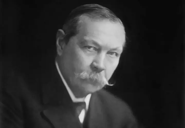 Sir Arthur Conan Doyle, kto jest autorem książek o Sherlocku Holmesie, na czarno-białym portrecie.