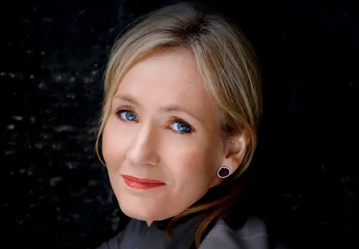 J.K. Rowling, autorka książki Harry Potter, z niebieskimi oczami i blond włosami, patrzy w obiektyw.