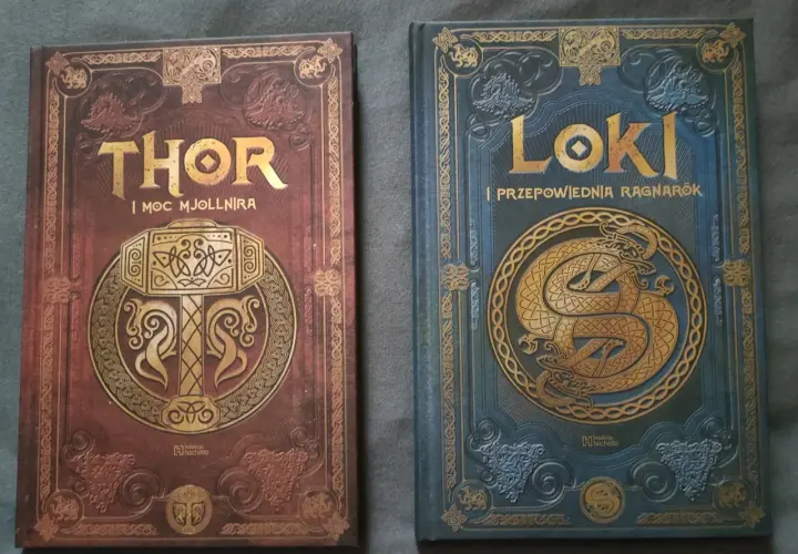 Dwie książki z motywami nordyckimi: "Thor i moc Mjolnira" z młotem, oraz "Loki i przepowiednia Ragnarök" z wężem. Poznaj symbole nordyckie i ich znaczenie.