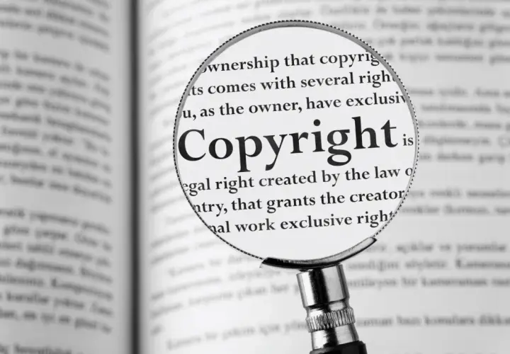 Lupa powiększa słowo "Copyright" w książce, pokazując, jak zapisać cytat zgodnie z prawem.