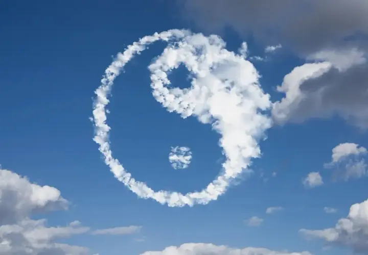 Symbol Yin Yang uformowany z chmur na tle błękitnego nieba.