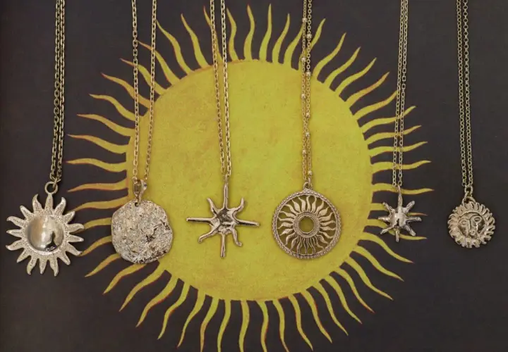 Pięć złotych naszyjników z motywem słońca. Symbol słońca znaczenie: życie, moc, energia.