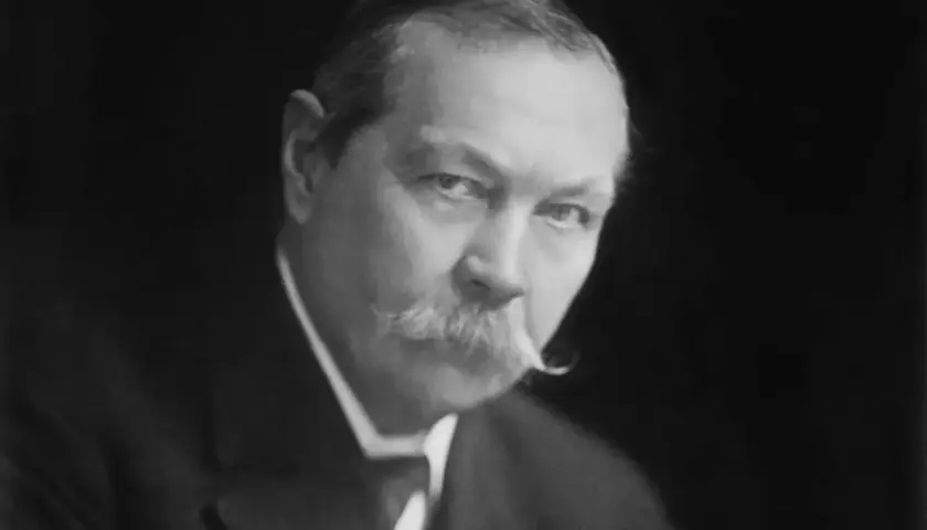 Sir Arthur Conan Doyle, kto jest autorem książek o Sherlocku Holmesie, na czarno-białym portrecie.