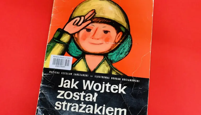Okładka książki "Jak Wojtek został strażakiem" z ilustracją chłopca w hełmie.