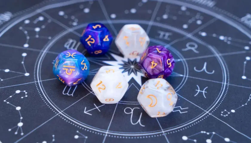 Siedem kostek z symbolami magicznymi i ich znaczeniem, ułożonych na tle wykresu astrologicznego.