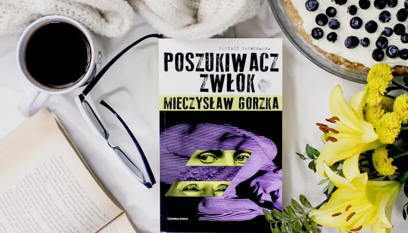 Recenzja książki "Poszukiwacz zwłok" Mieczysława Gorzki. Kawa, okulary, otwarty tom i ciasto z jagodami tworzą idealny nastrój do czytania.