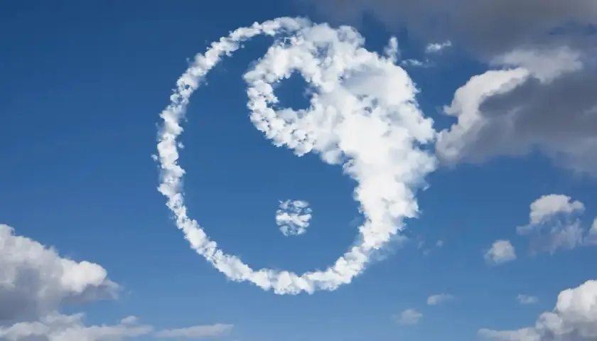 Symbol Yin Yang uformowany z chmur na tle błękitnego nieba.
