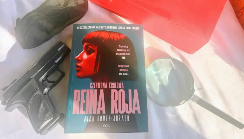 Recenzja książki "Czerwona Królowa" Juana Gómeza-Jurado. Obok leży pistolet i lupa, sugerując kryminalną fabułę.