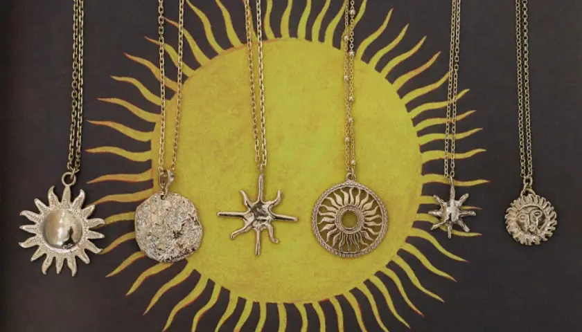 Pięć złotych naszyjników z motywem słońca. Symbol słońca znaczenie: życie, moc, energia.