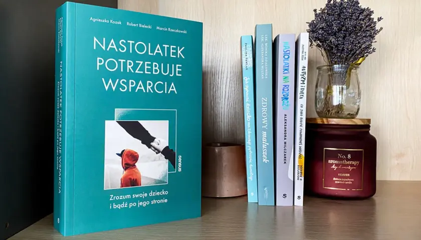 Recenzja książki o wychowaniu: "Nastolatek potrzebuje wsparcia". Na półce obok inne poradniki dla rodziców i świeca.