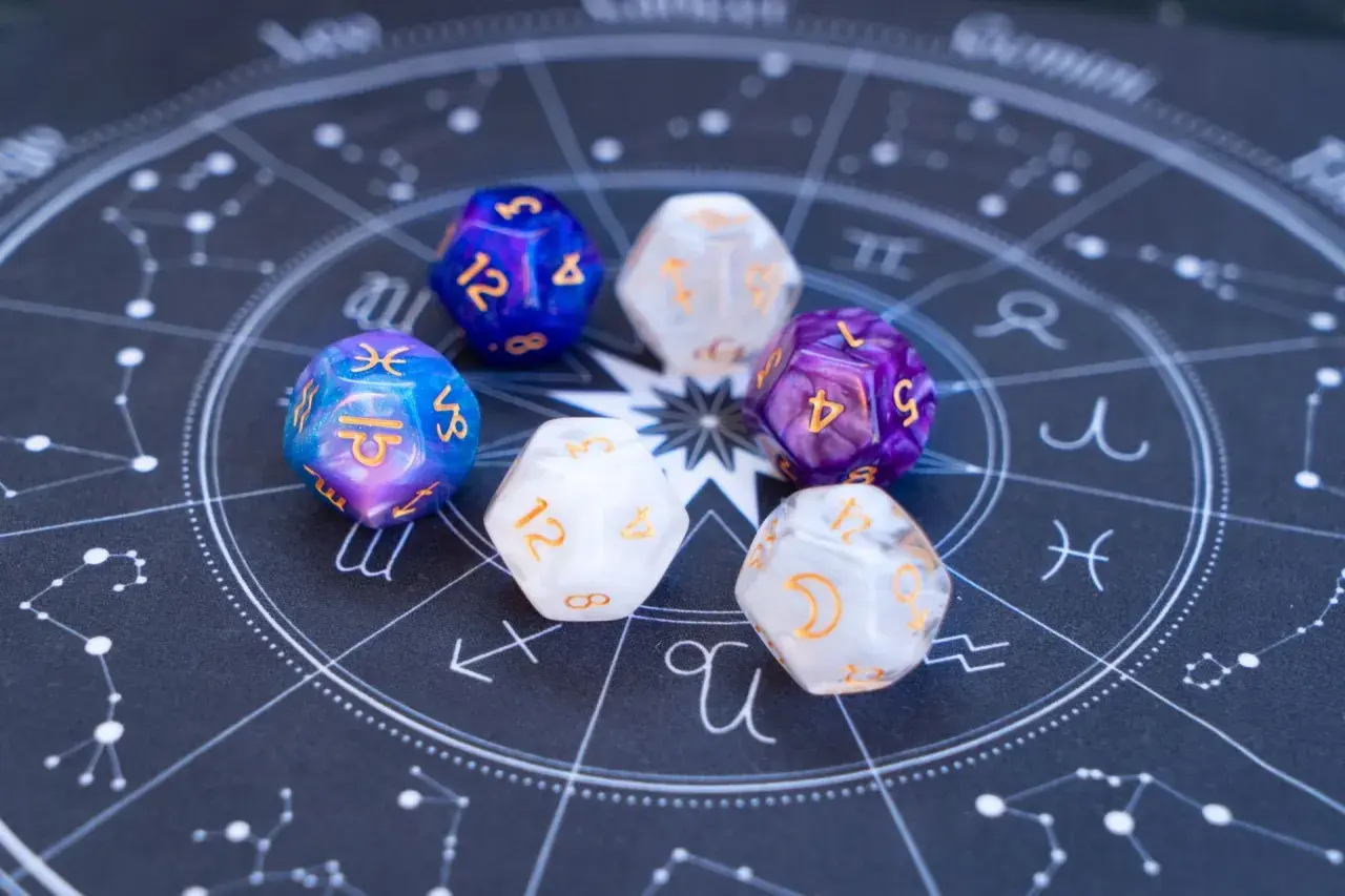 Siedem kostek z symbolami magicznymi i ich znaczeniem, ułożonych na tle wykresu astrologicznego.