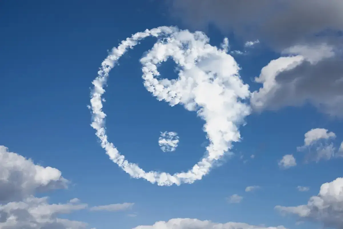 Symbol Yin Yang uformowany z chmur na tle błękitnego nieba.