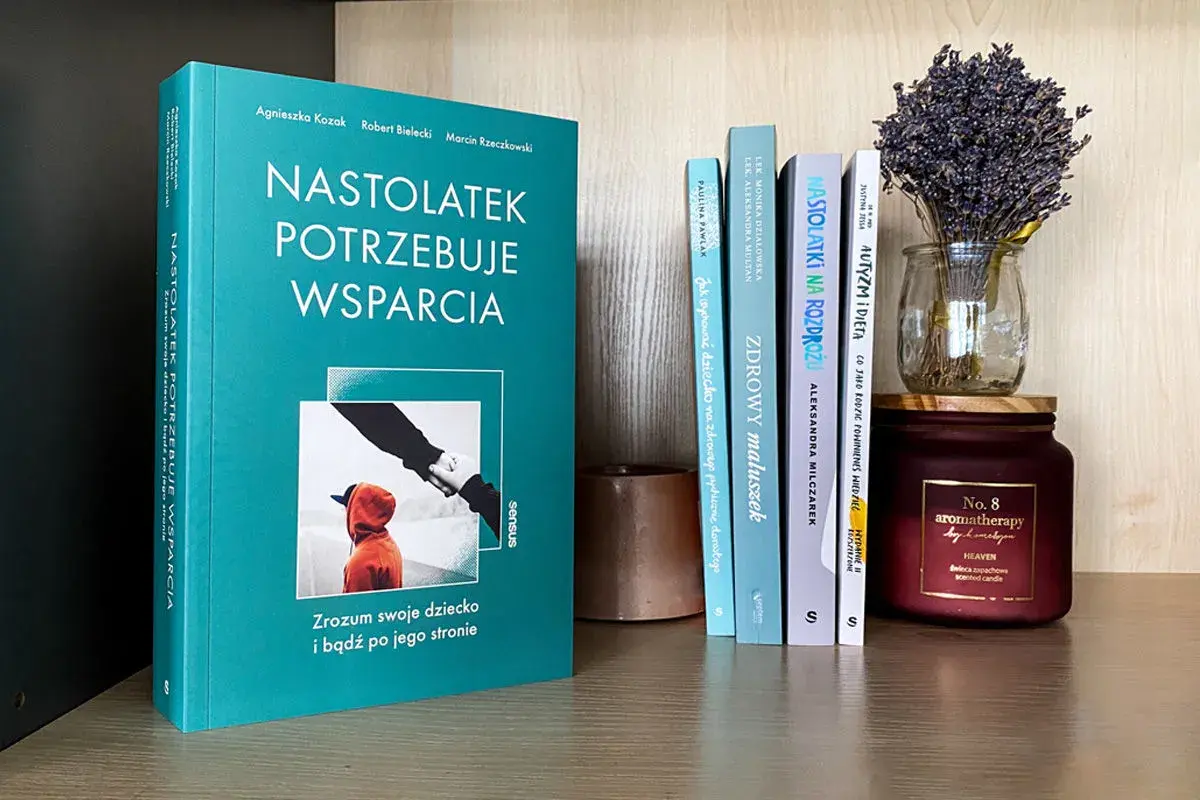 Recenzja książki o wychowaniu: "Nastolatek potrzebuje wsparcia". Na półce obok inne poradniki dla rodziców i świeca.